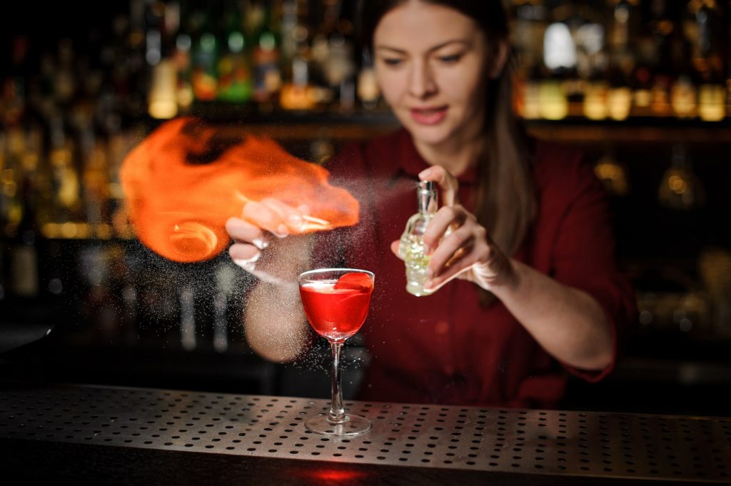 Female bartender showing off advanced cocktail making skills