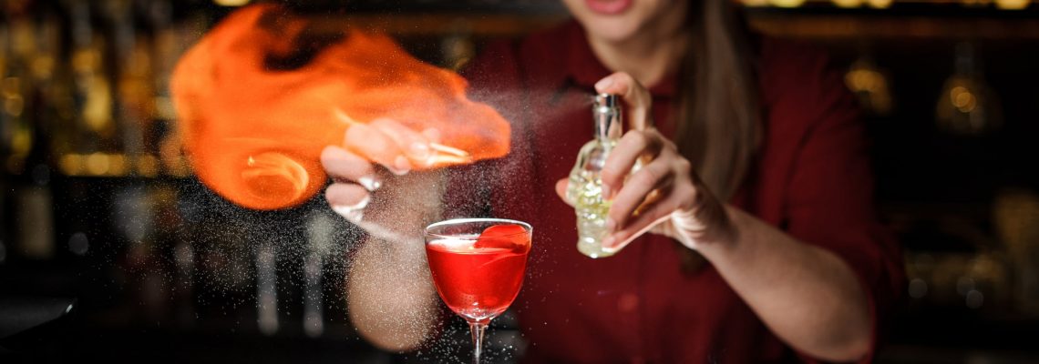 Female bartender showing off advanced cocktail making skills