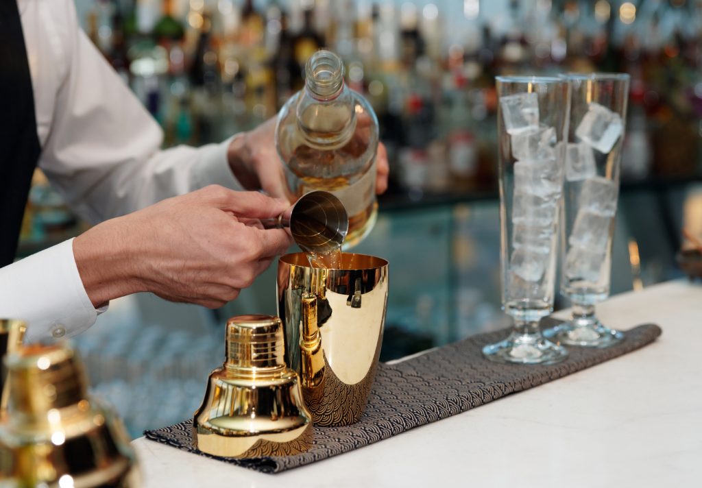 Bartender making a cocktail after watching mixology online